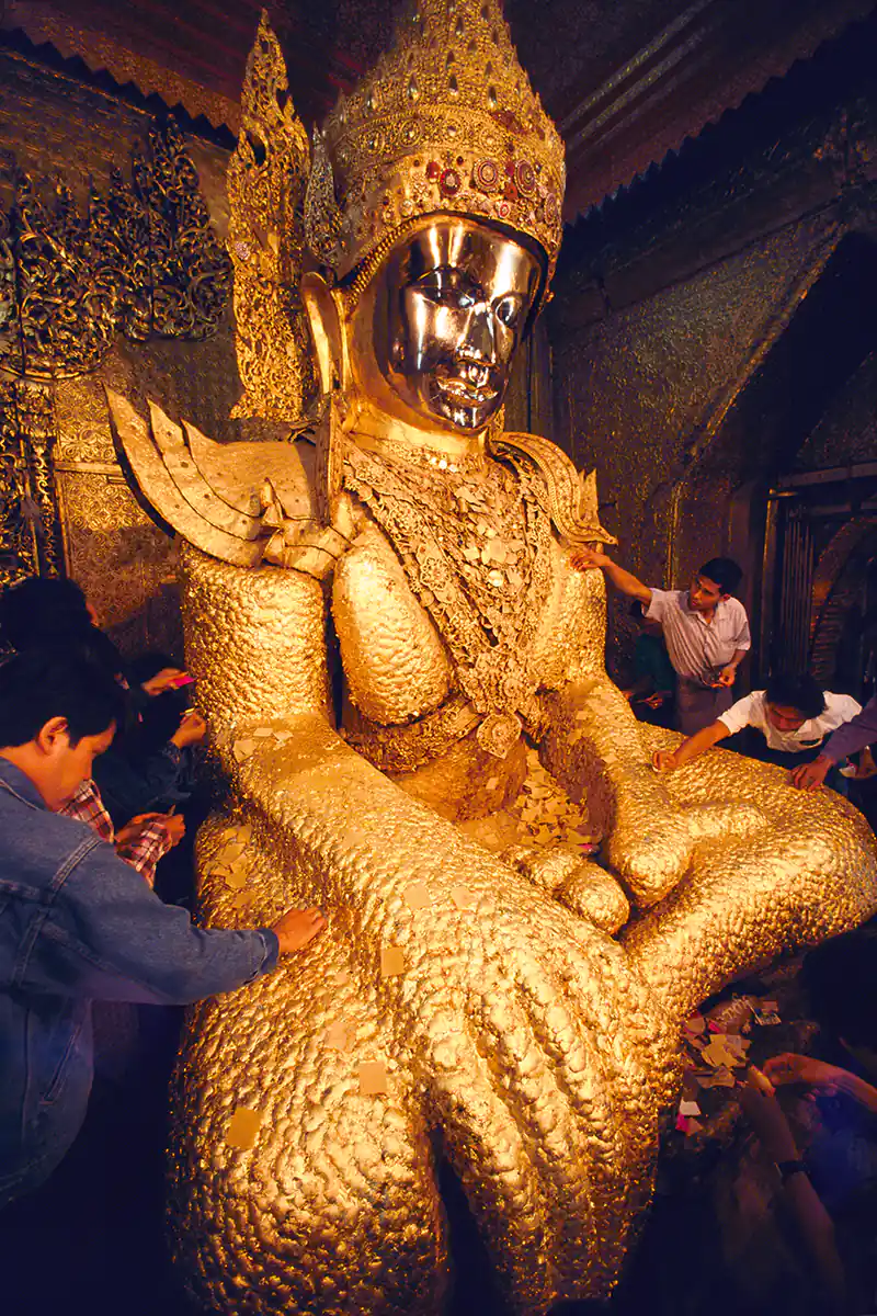 Pilgrims applying gold leaf to the Maha Muni Buddha Mandalay, Myanmar (Burma)