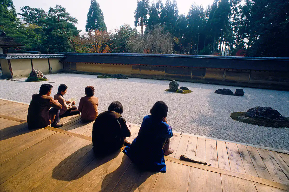 Pilgrims meditating at the Zen garden of Ryoan-ji, Kyoto, Japan