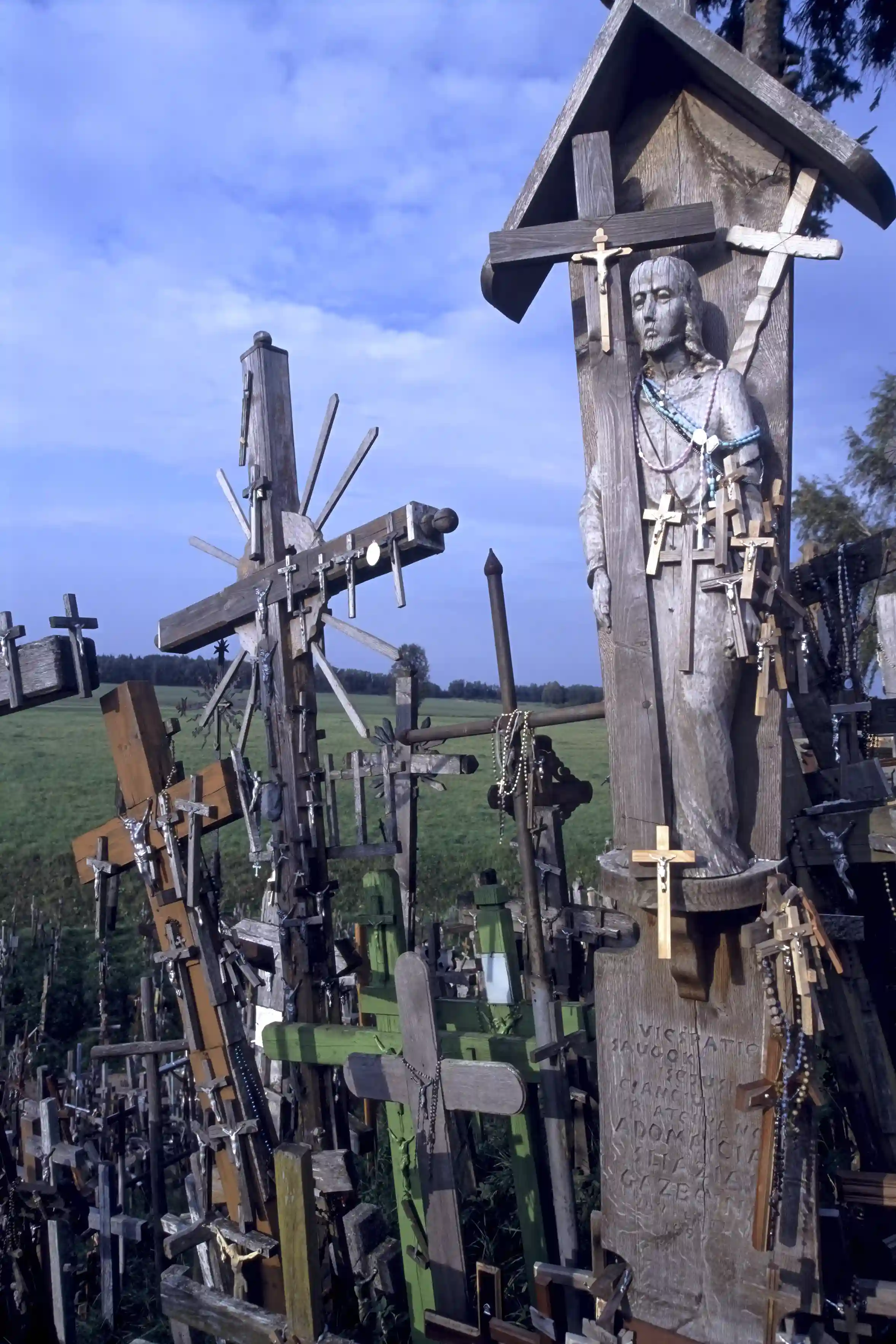Statue of Christ and crosses left by pilgrims, Hill of Crosses Statue of Christ and crosses left by pilgrims, Hill of Crosses