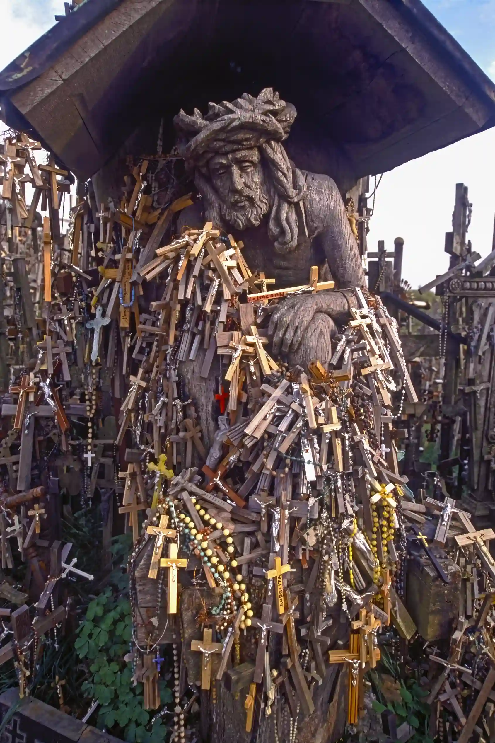 Statue of Christ and crosses left by pilgrims, Hill of Crosses Statue of Christ and crosses left by pilgrims, Hill of Crosses