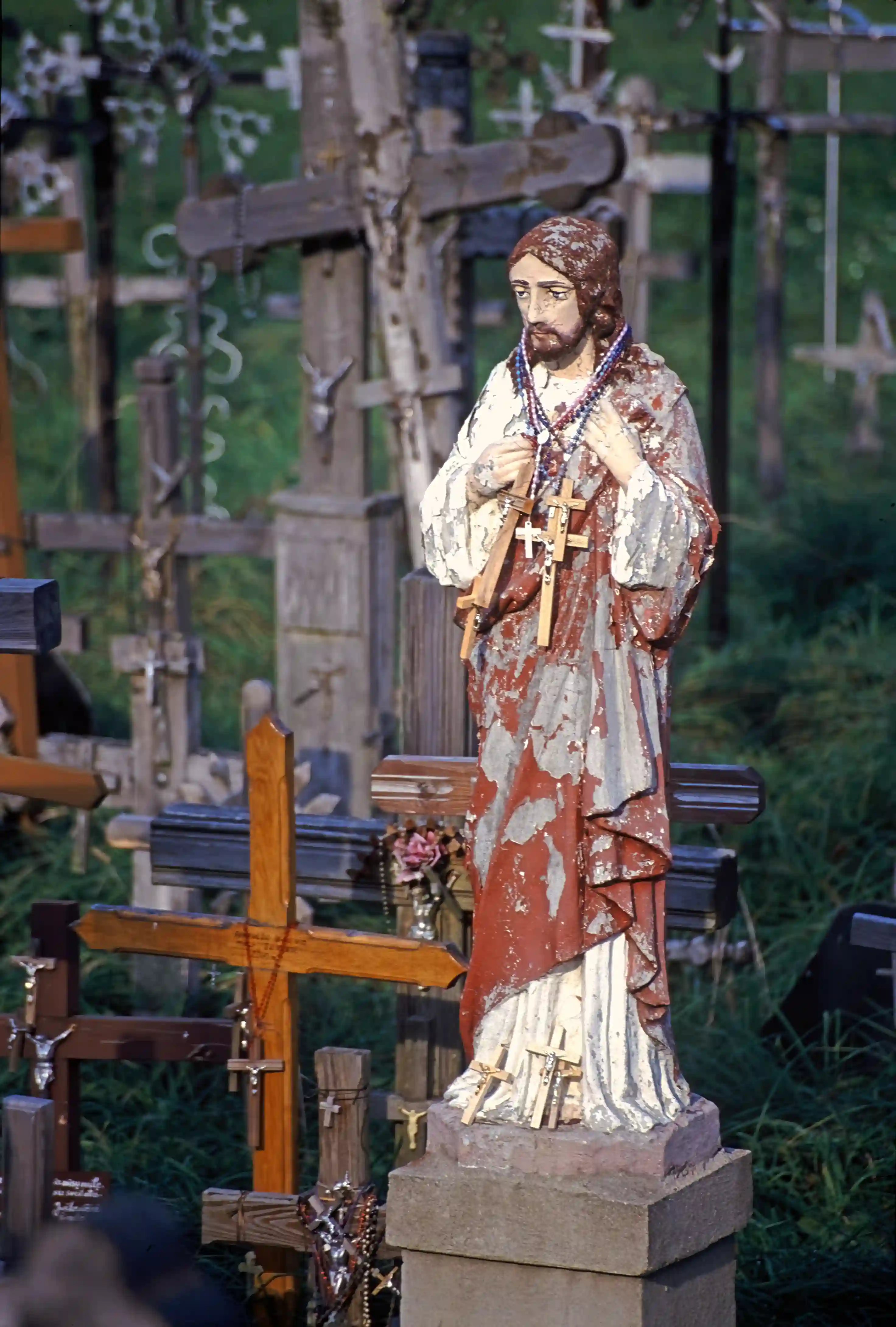 Statue of Christ and crosses left by pilgrims, Hill of Crosses Statue of Christ and crosses left by pilgrims, Hill of Crosses